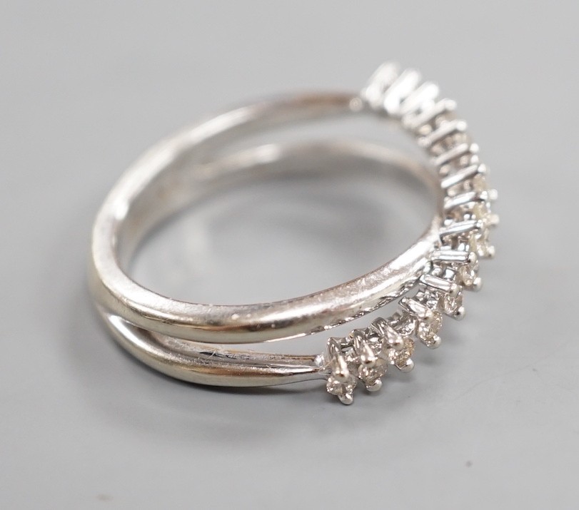 A modern 18ct white gold and diamond chip set half hoop crossover ring, size O, gross weight 3.9 grams.